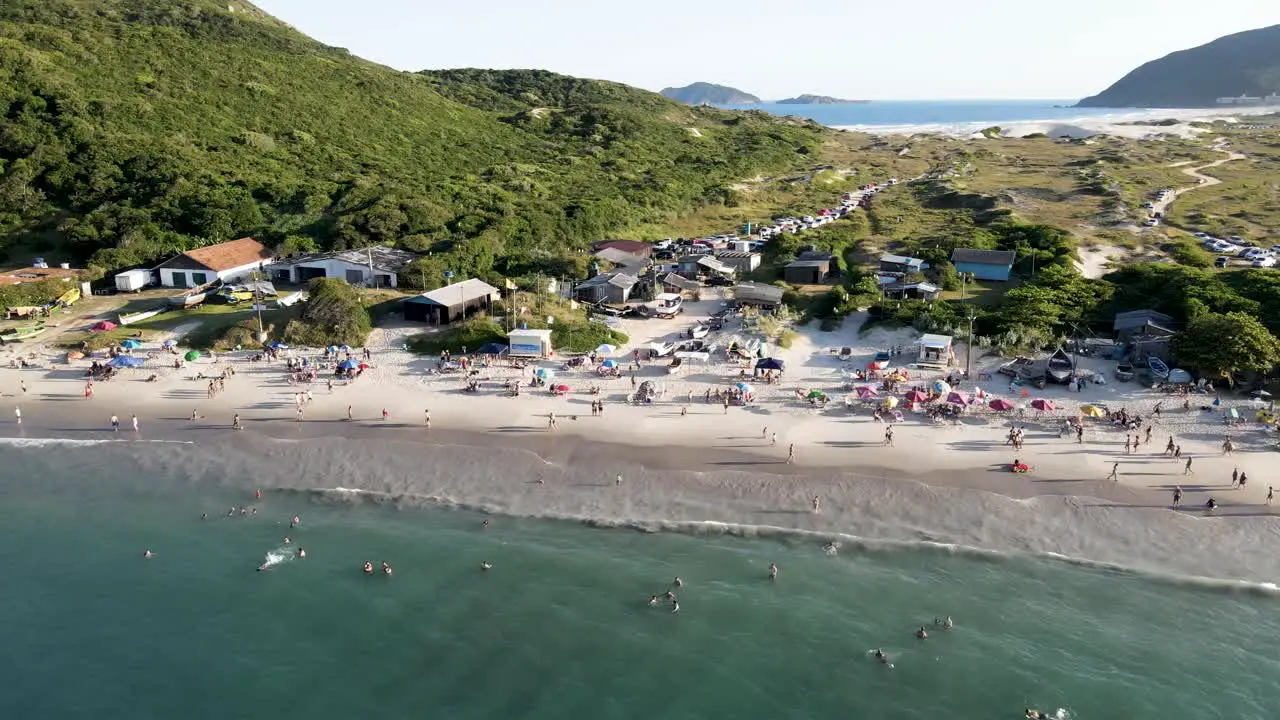 Aerial drone scene with beach and people enjoying the sunset on the dunes and having fun in the sand on top of the dunes of Florianópolis Brazil in front ocean