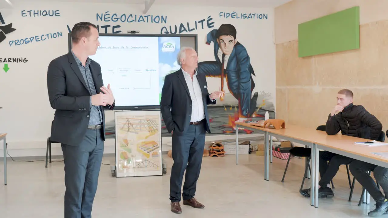 Slow motion orbiting shot of people teaching employees about roof renovation