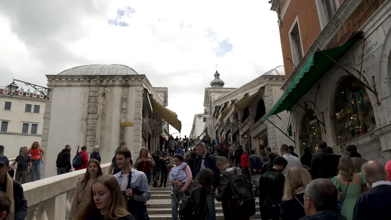 Busy Scene With Tourists At Bottom Of Rialto Bridge In Venice