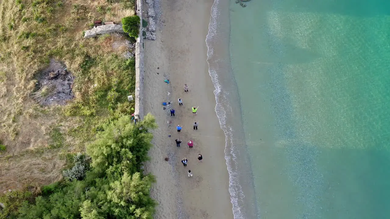 Aerial View Of Group Of People Doing Yoga On The Beach