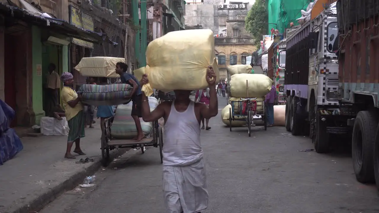 One laborer carries the goods on his head