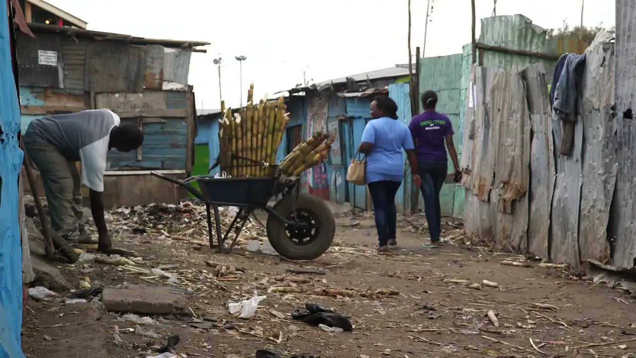 Man working and loading a wheelbarrow in a slum in Kenya