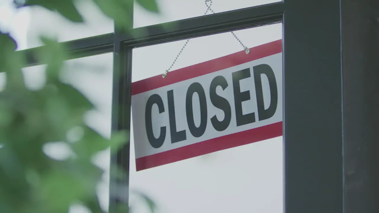 An employee flips a sign on a store window