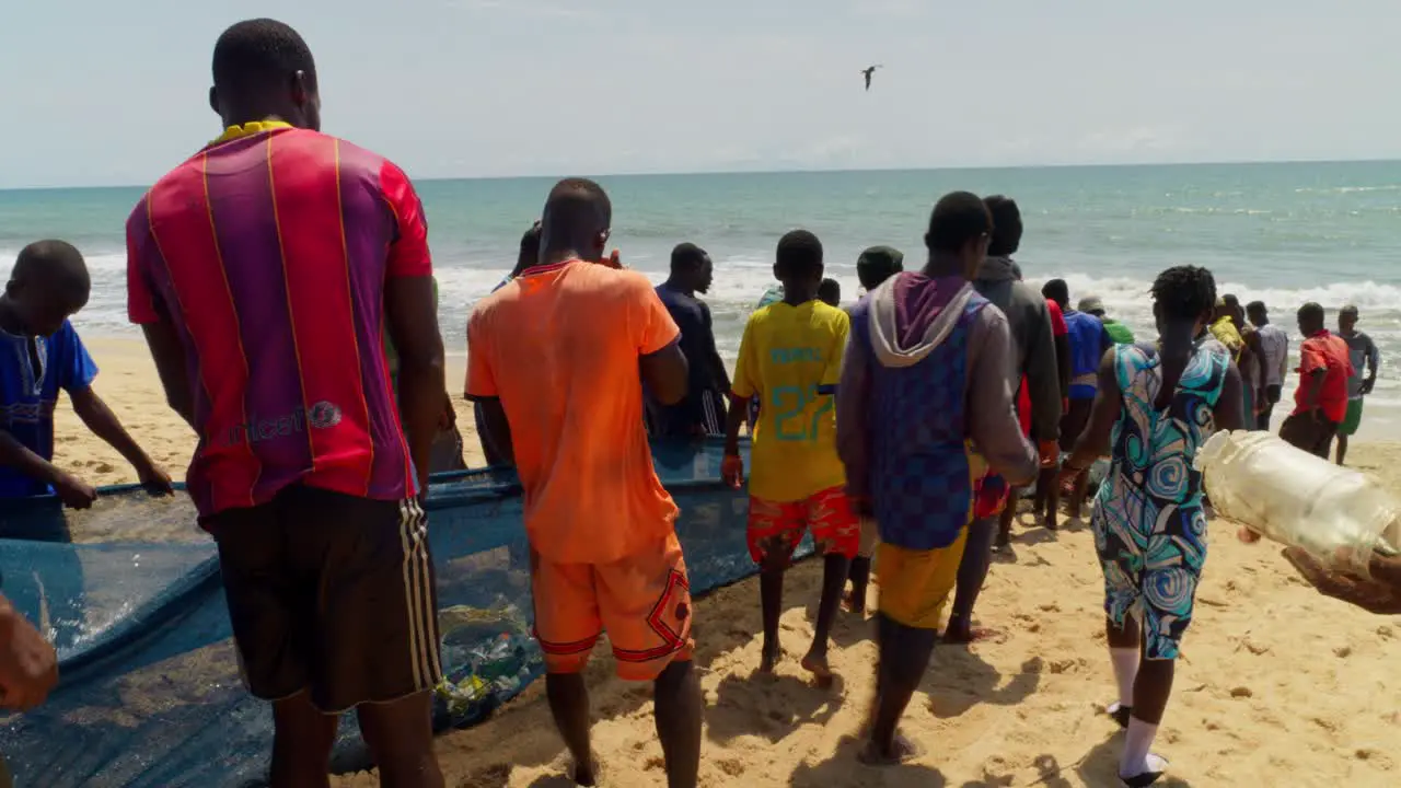 African people working together on the beach with fishing nets