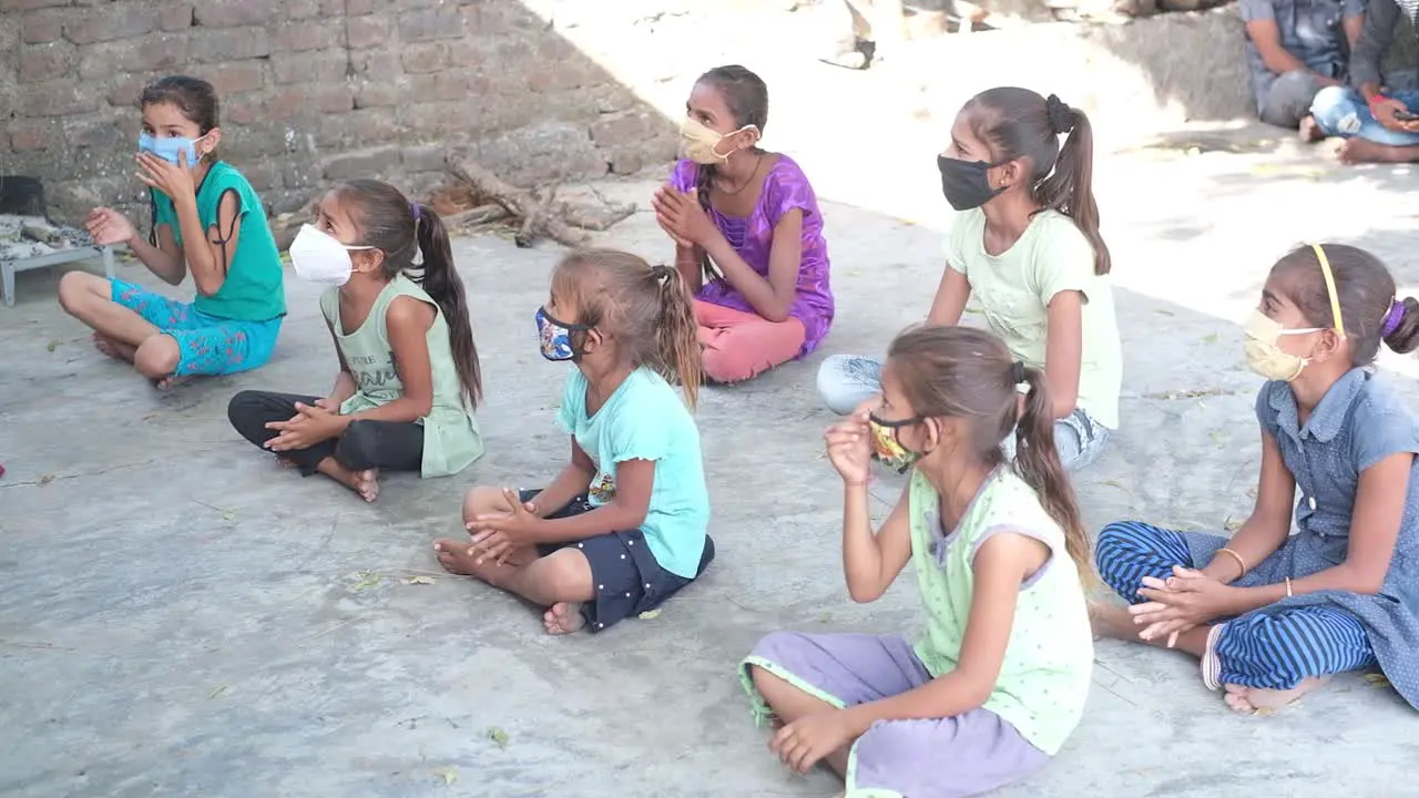 Scene from above showing slum and working class children attending primary school younger children applauding the teacher in the classroom