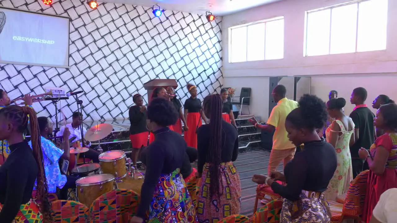 Happy African people dancing in local festivity inside rustic church