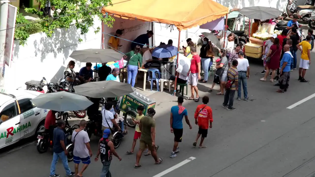 People from the Philippines are gathering alongside the road in Davao City