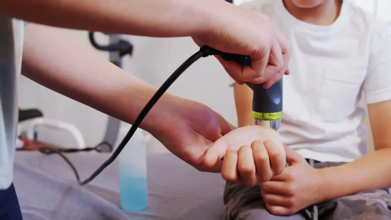 Physiotherapist giving hand massage to a boy 4k