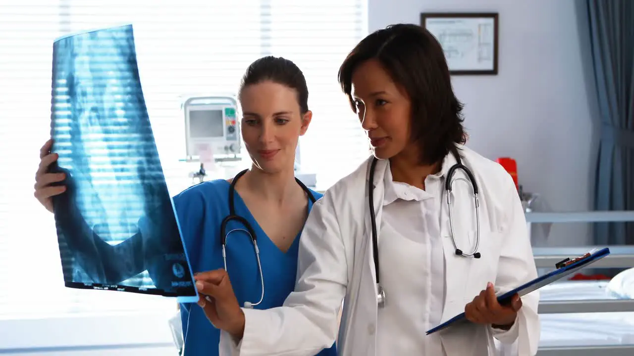 Male and female doctor discussing over x-ray report