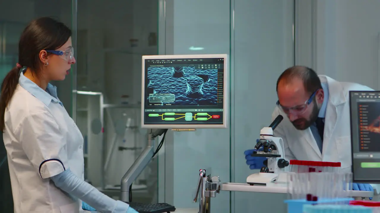 Scientist team checking virus development using microscope