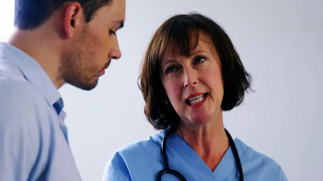 Doctors discussing over digital tablet in corridor