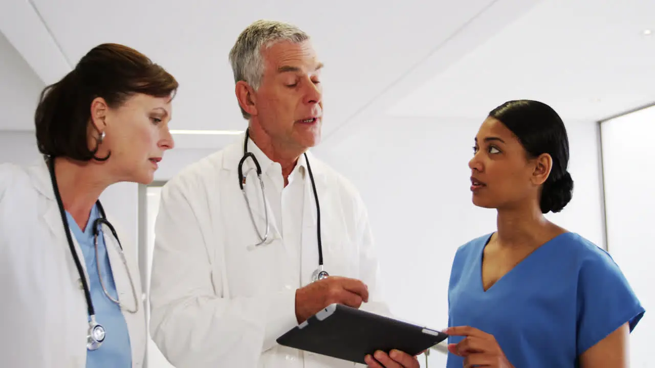 Doctors and nurse discussing over digital tablet