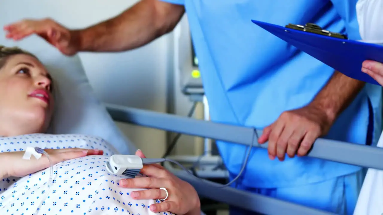 Doctor consulting pregnant woman in ward