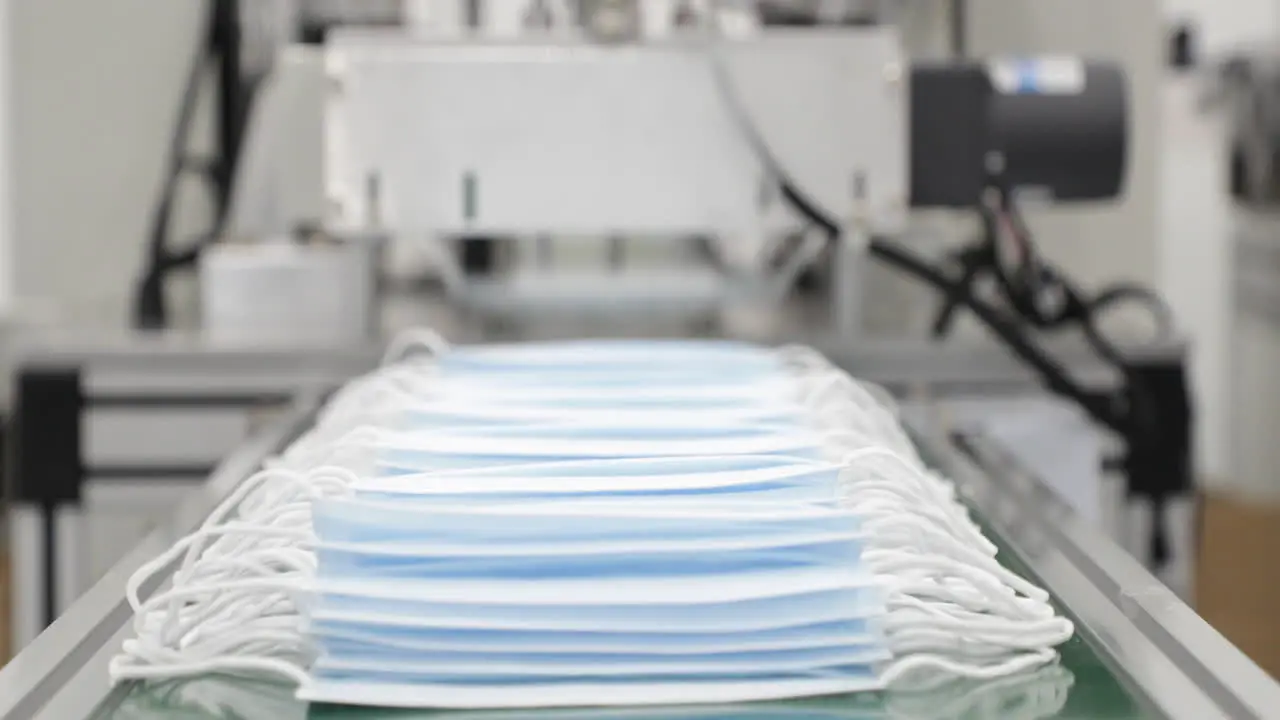 Heap Of Blue Disposable Medical Masks On Conveyor IIn Factory Ready For Packaging