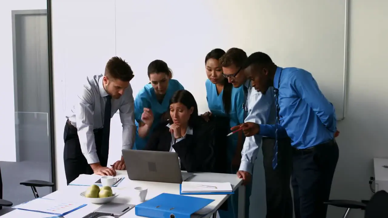 Team of doctors discussing over laptop