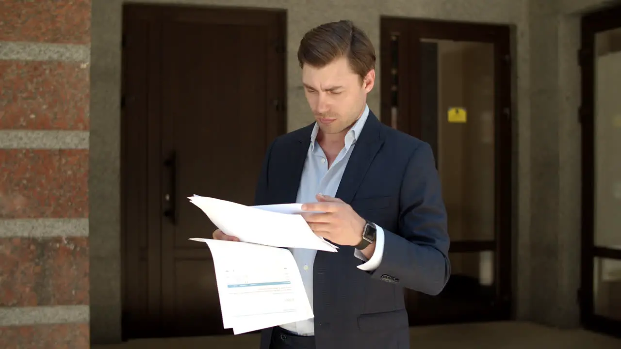 Closeup man reading business papers Man studding business documents at street