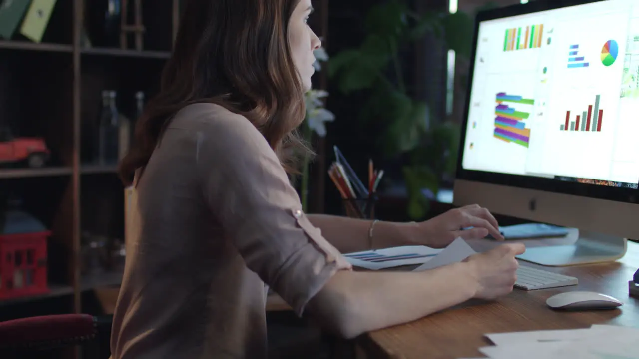 Young woman business analyst using computer to generate financial report