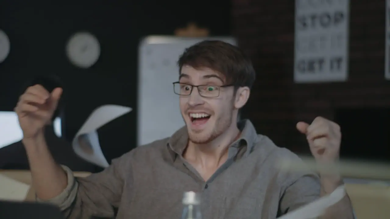 Surprised business man celebrating good results in front of laptop in office