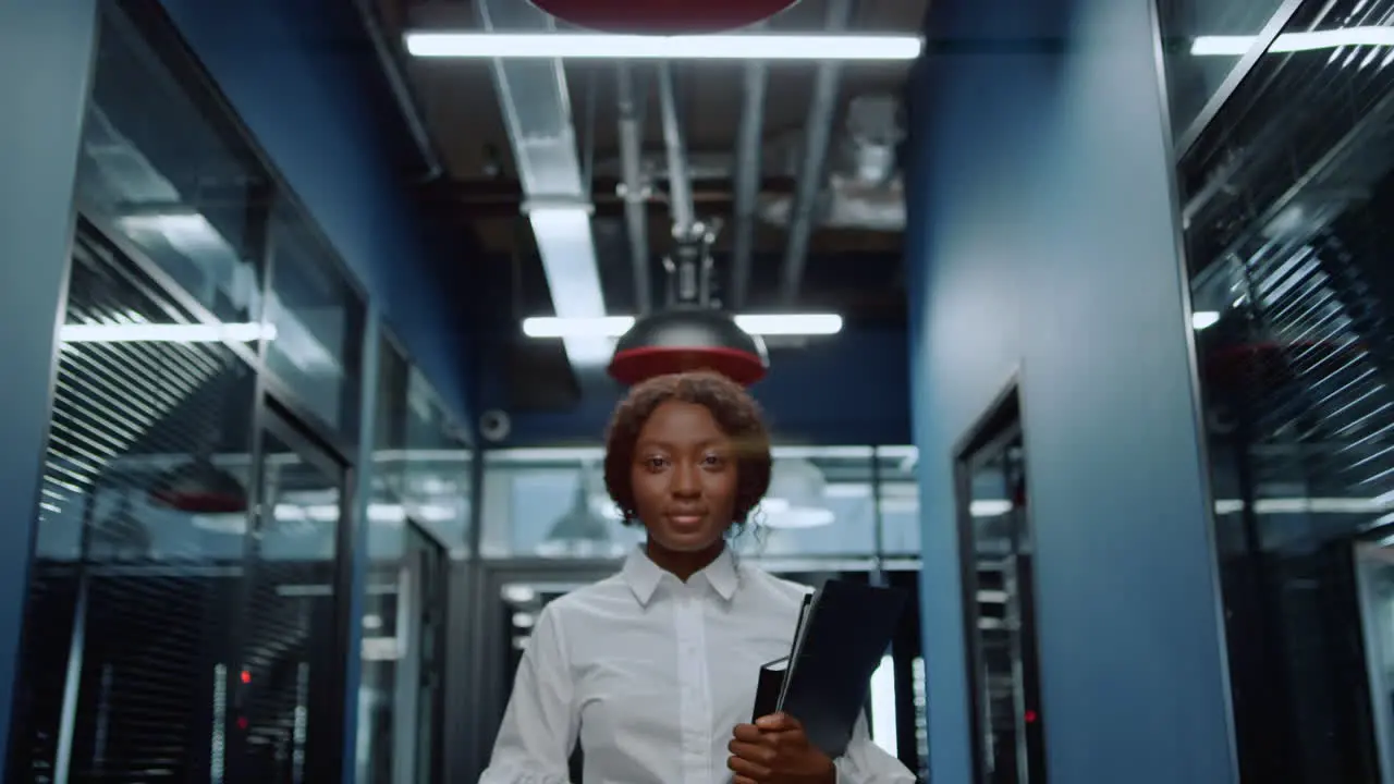 Cheerful afro woman looking at camera in corridor Woman smiling in office