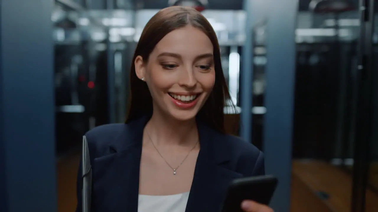 Excited woman looking smartphone in office Lady reading message in corridor