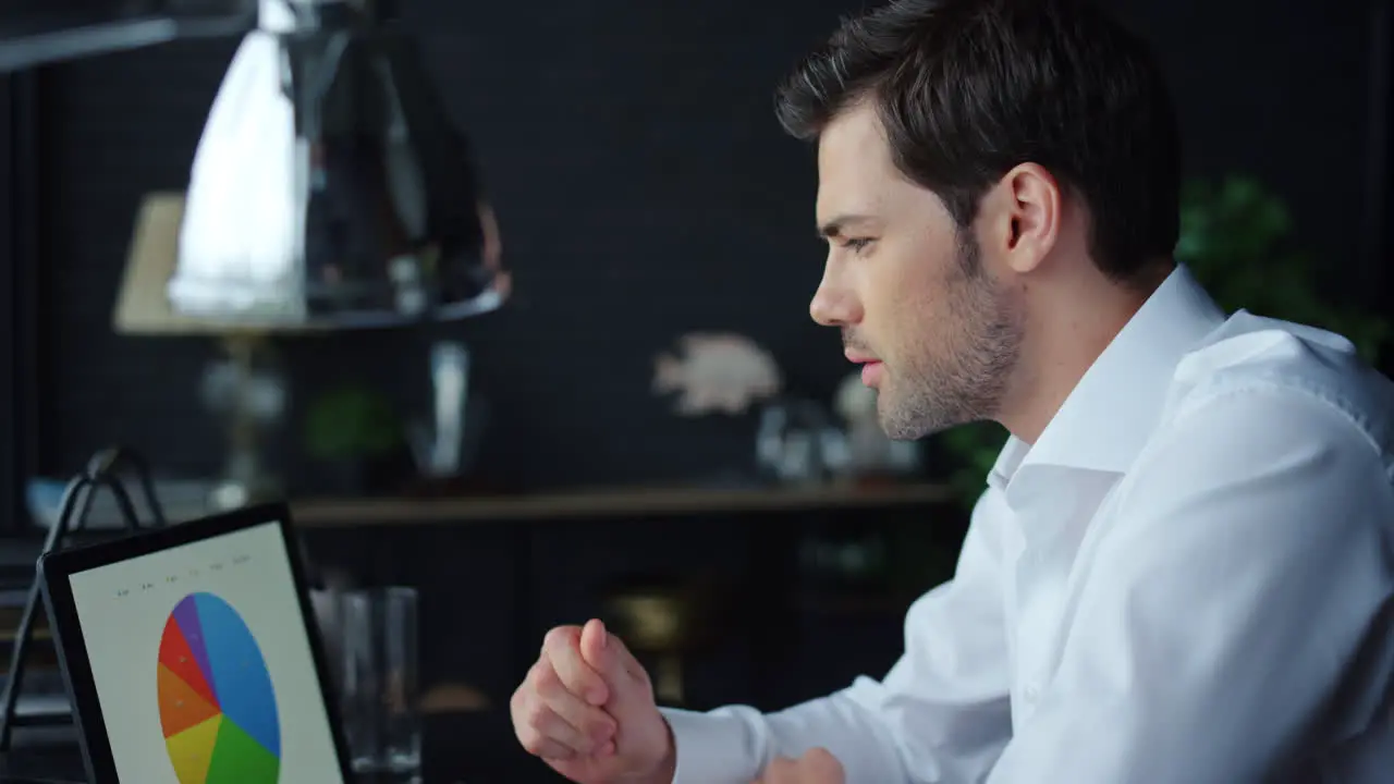 Businessman looking at graphs on laptop in office Man working on laptop