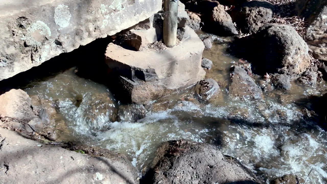 Pan follow of flowing creek water from waterfall to pond Ju Raku En Japanese Garden Toowoomba Australia