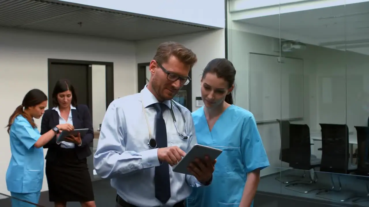 Doctors discussing over digital tablet with nurse