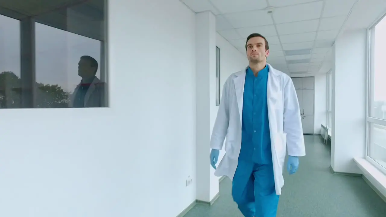 Medical worker walking in white corridor Male doctor walking hospital corridor