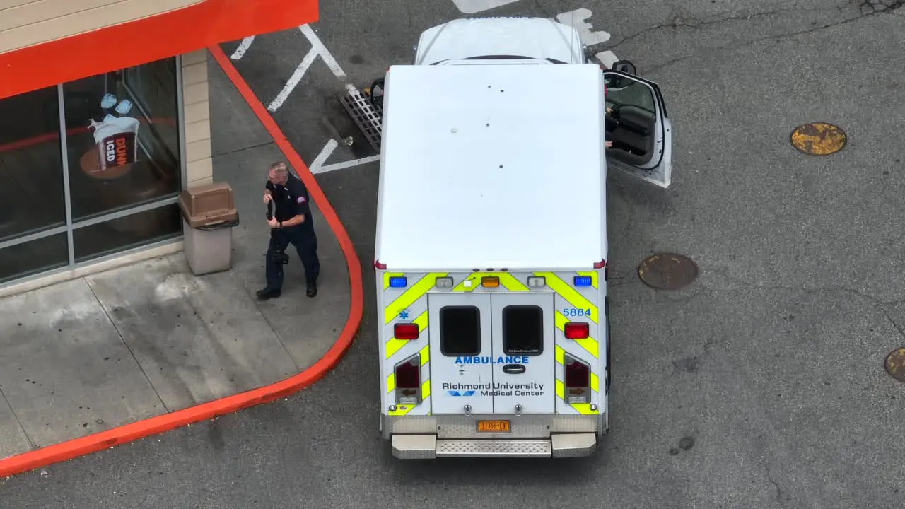 Top view of emergency healthcare male nurses stepping down from Medical Ambulance van and walking down the street Staten Island