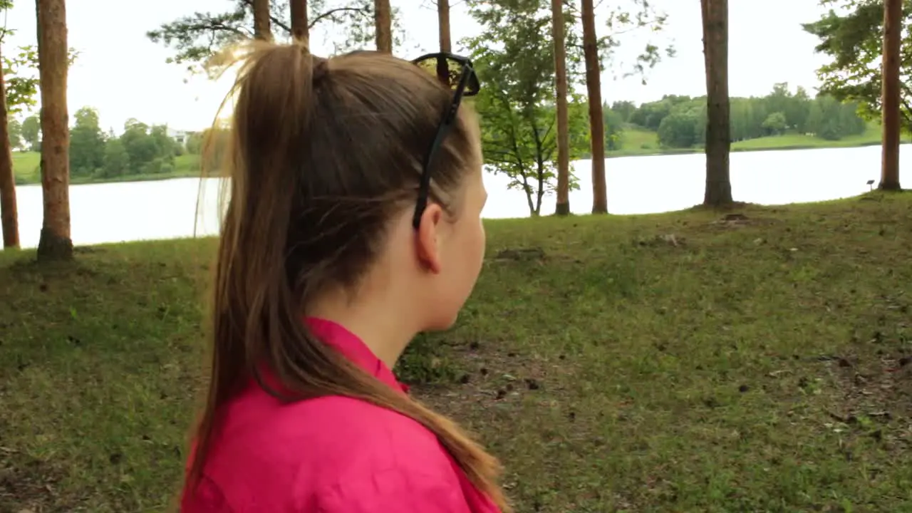 Girl walking in the park next to a lake