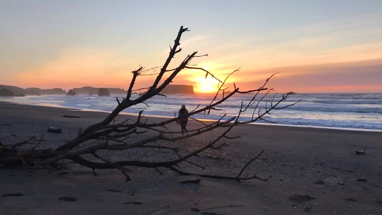 Woman walking at Bandon Beach during a beautiful sunset