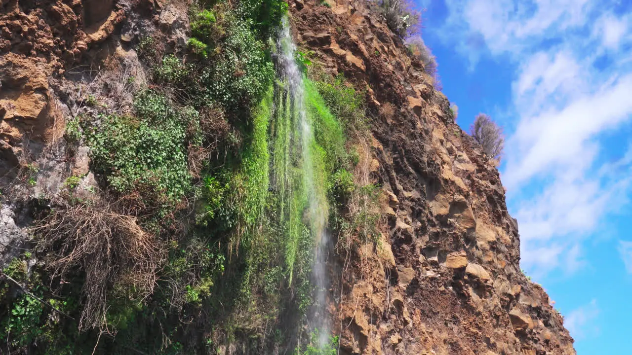 Small stream of water falling from the steep mountain