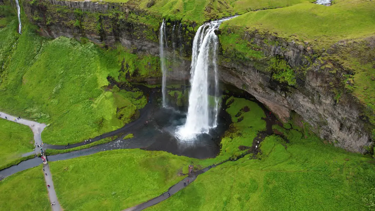 Iconic Iceland waterfall with green nature around aerial drone view