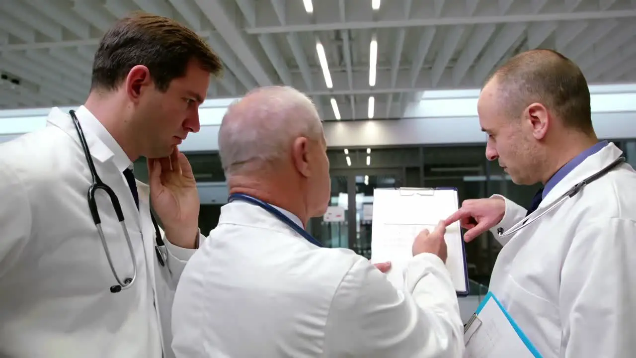 Team of doctors discussing over clipboard