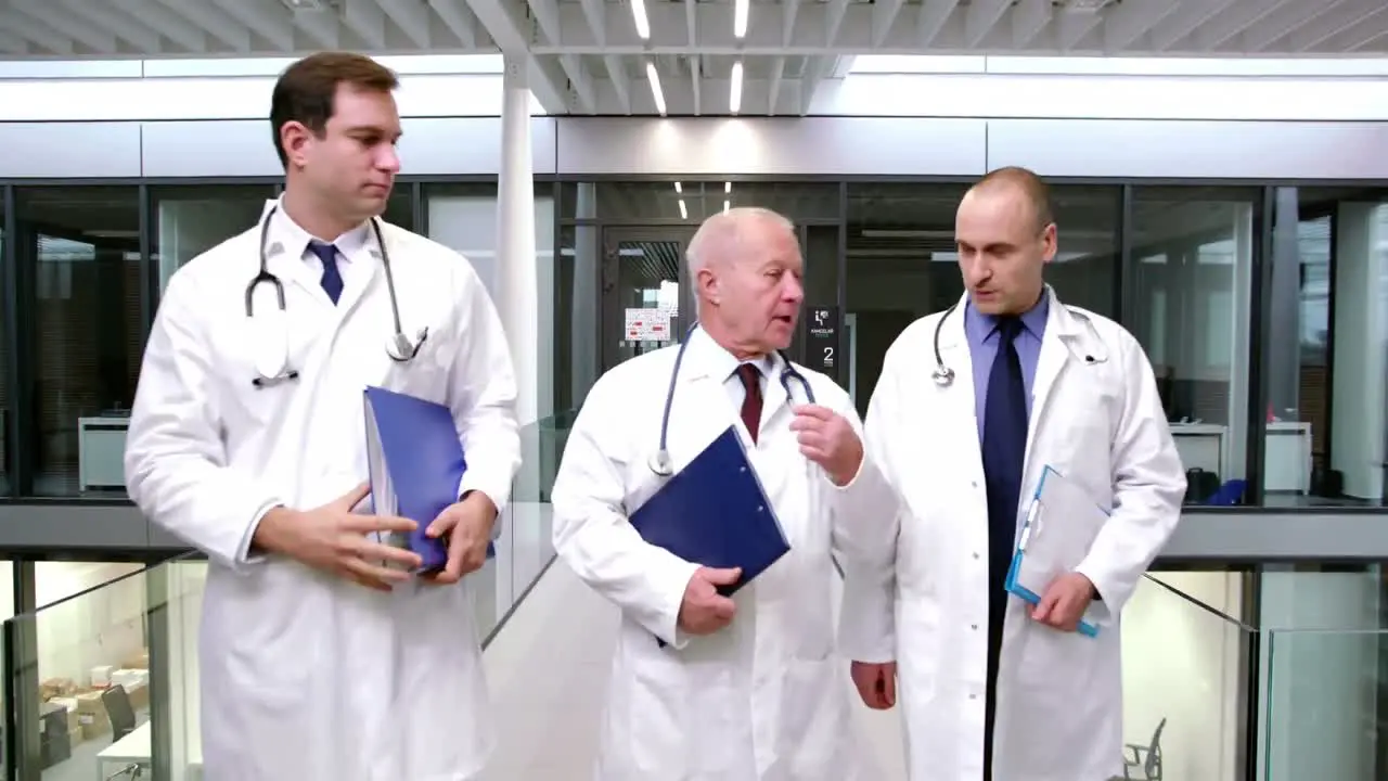 Doctors interacting with each other while walking in corridor