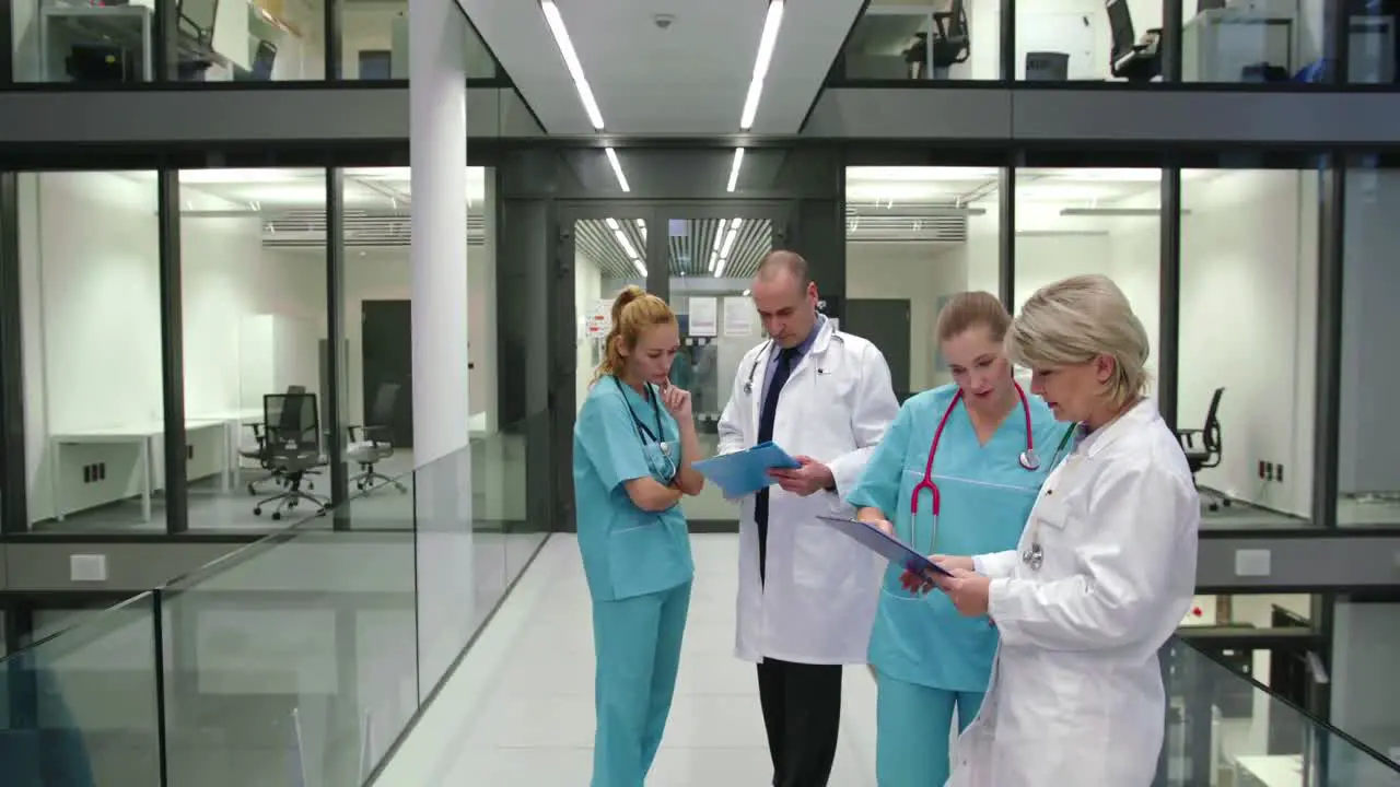 Doctors discussing over medical report in corridor