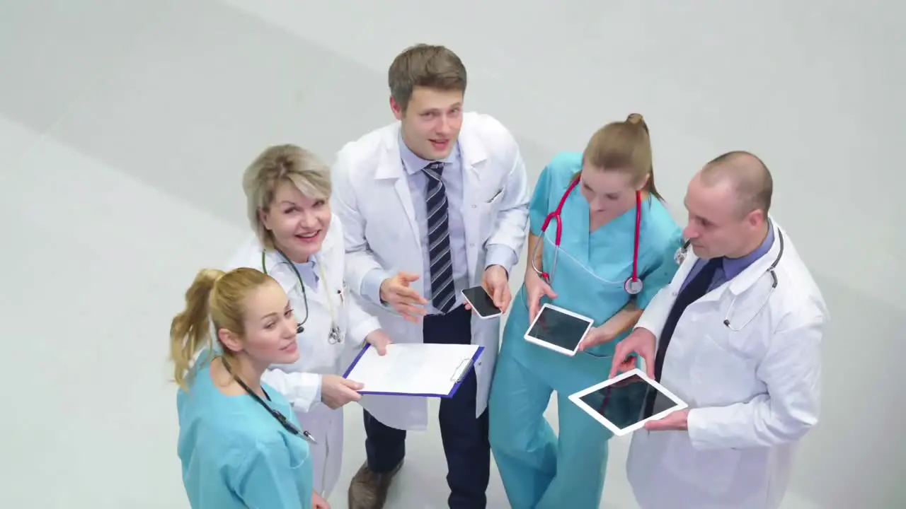 Team of doctors interacting with each other in corridor