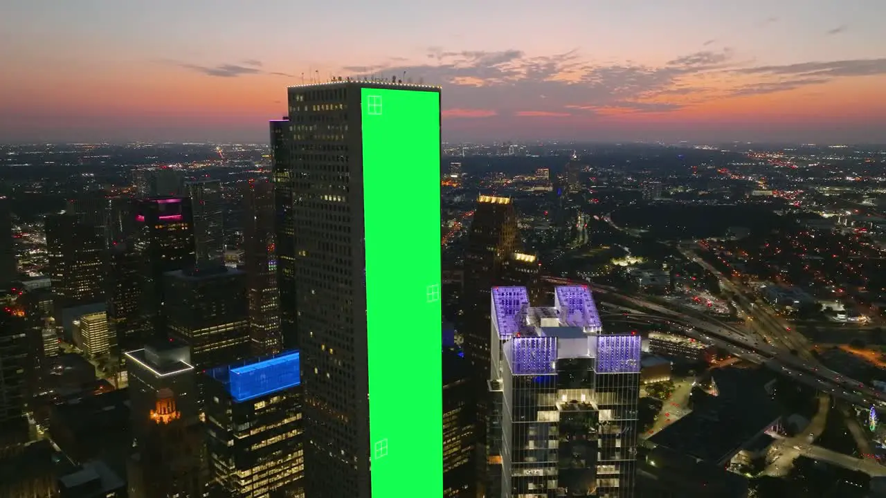 Green screen banner tracked on a skyscraper wall dusk city background VFX visuals