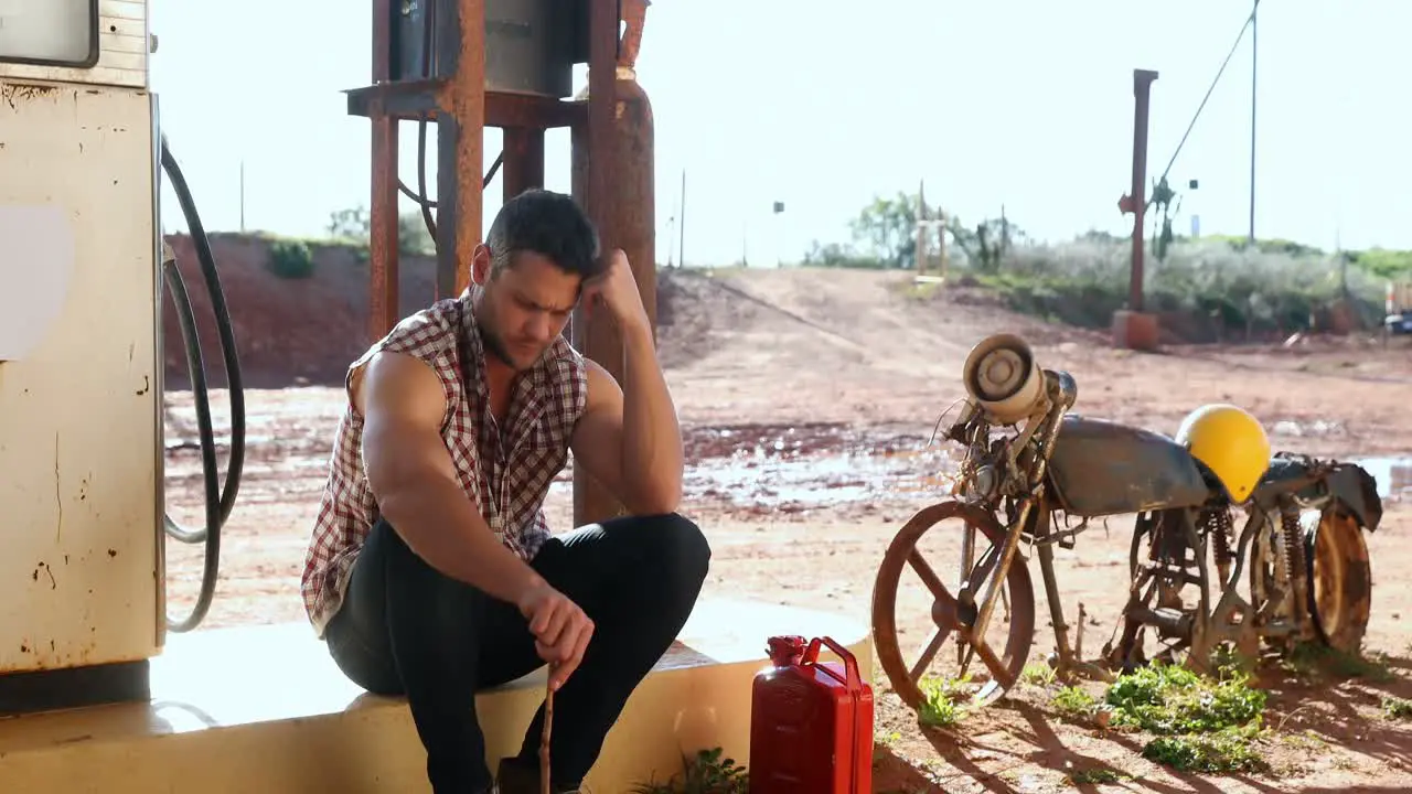 Man sitting at petrol pump station 4k