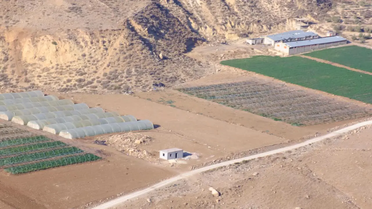 View of food production farms fruit crops surrounded by a vast dry terrain in Jordan Middle East pan from right to left