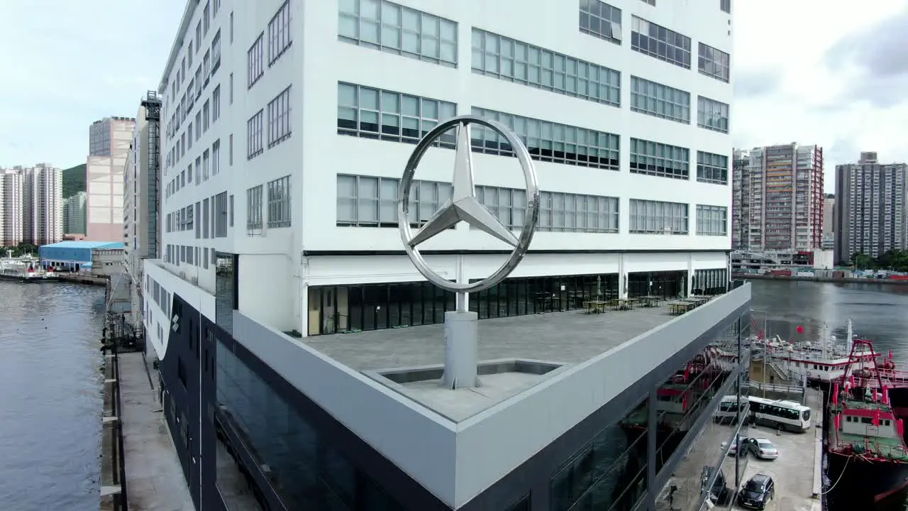 Large Mercedes Benz sign spinning on top of Hong Kong Mercedes Benz main showroom in Chai Wan area Aerial view