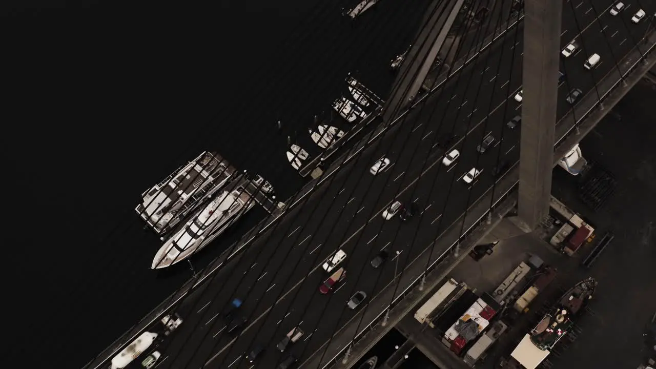 Peak hour and rush hour traffic travelling over a suspended bridge into a downtown district