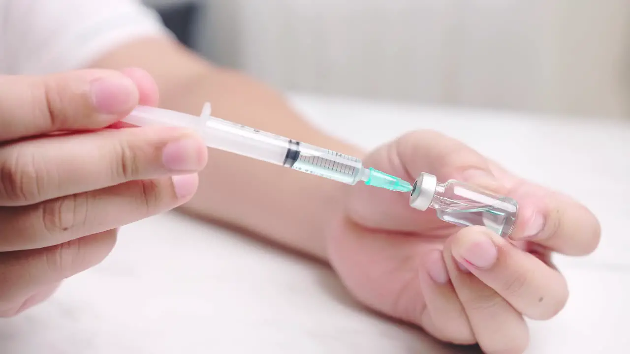 Man performing suction vaccine ampoule