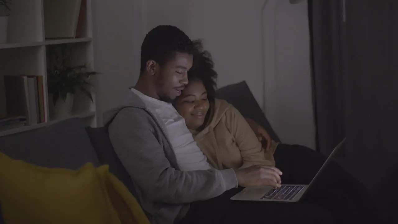 Young Couple Picking A Programme Or Film To Watch On The Laptop