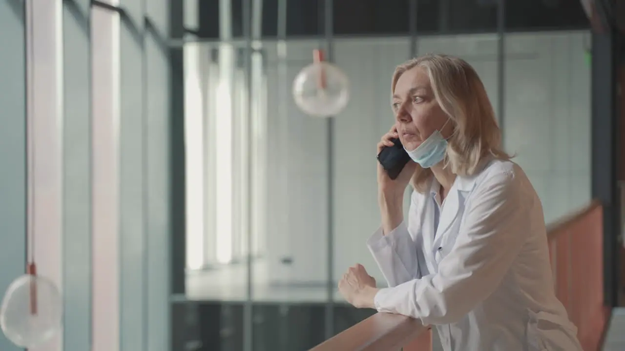 A Blonde Middle Aged Female Doctor Talks On The Cell Phone