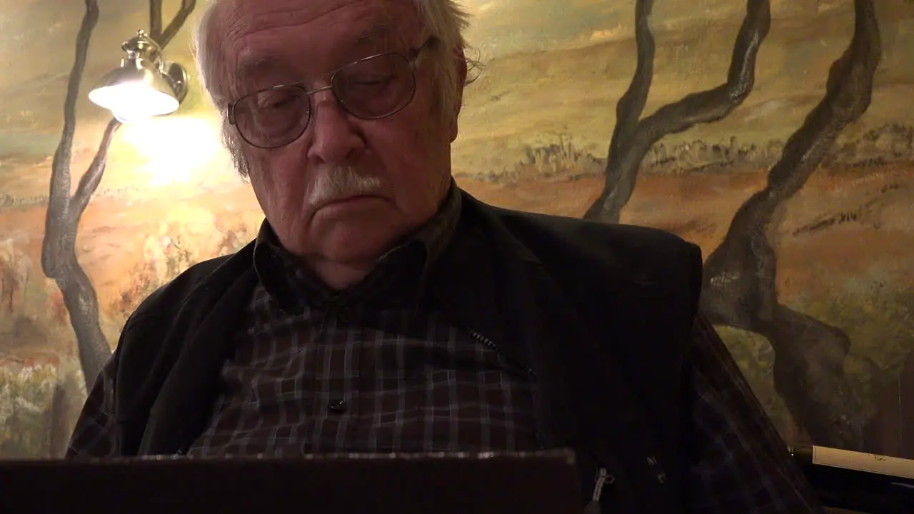 Man Reads Menu By Cafe Light