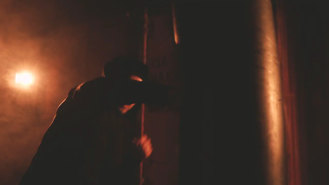 Man Athlete In Hoodie Hitting Punching Bag