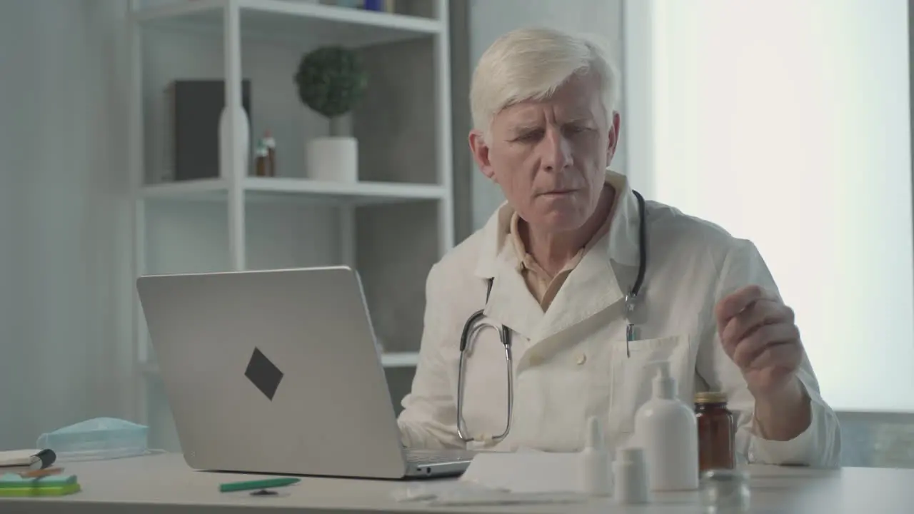 A Grey Haired Middle Aged Doctor Consults On His Laptop The Composition Of A Medicine 1