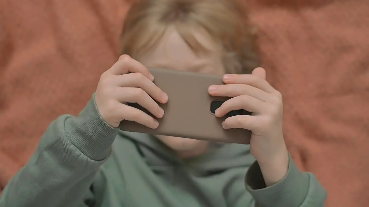 Portrait Of Little Boy With A Smartphone Watching An Online Video