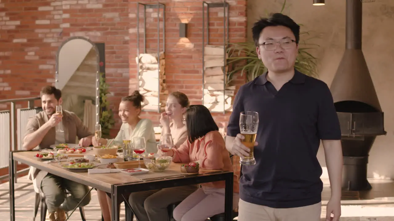 An Young Woman Drinking Beer At A Dinner Party